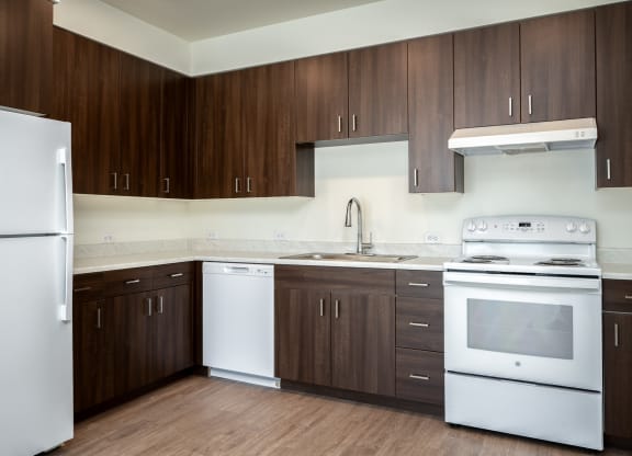 an empty kitchen with white appliances and wooden cabinets