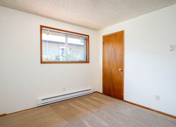 A room with a door, window, and carpet.