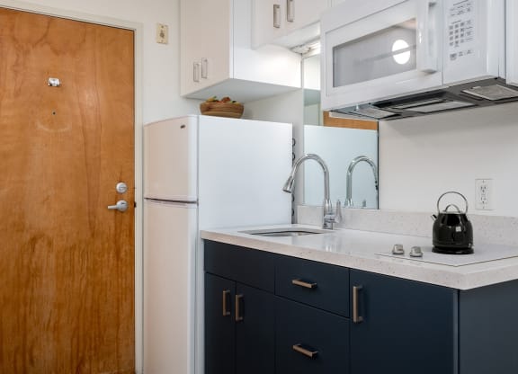 a kitchen with a sink and a refrigerator and a door