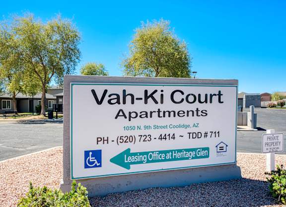 A sign for Vah-Ki Court Apartments is displayed in front of a building.
