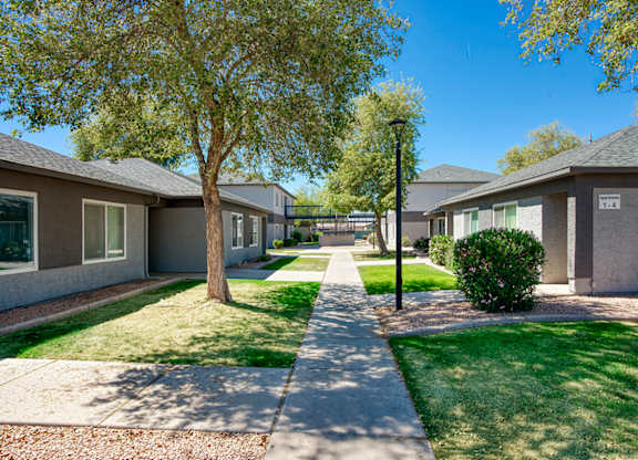 A row of houses with a sidewalk in between.
