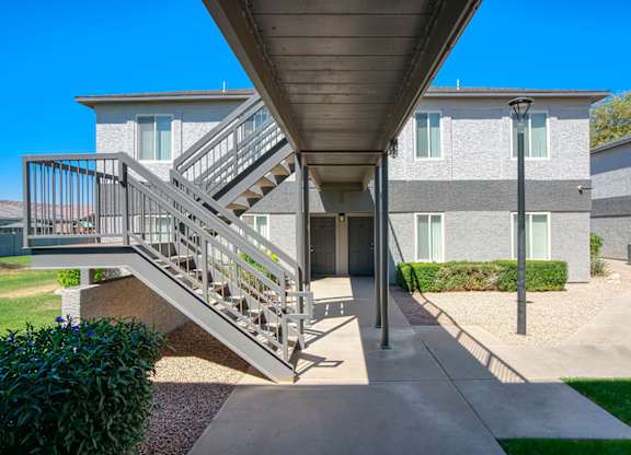 A staircase with a metal railing leads to a building.