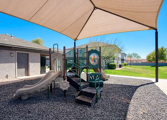 A playground with a slide and a wooden structure.