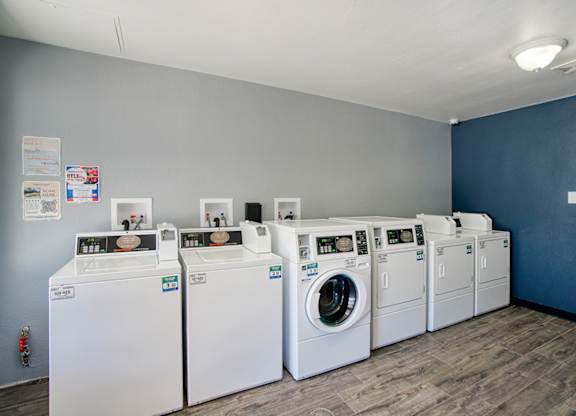 A row of washing machines are lined up in a laundromat.