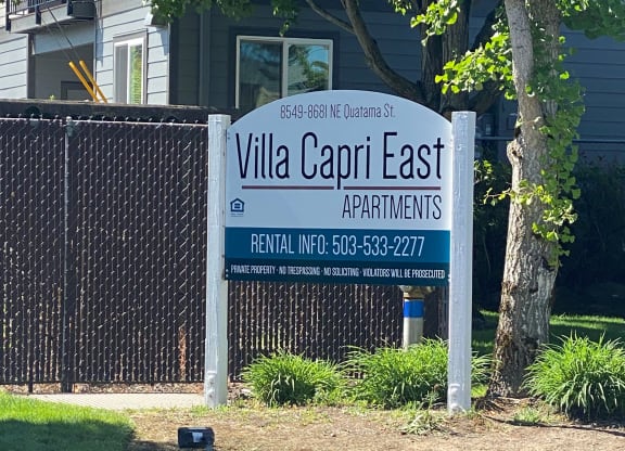 a sign for villa capri east apartments in front of a fence