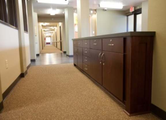 A long hallway with a brown cabinet on the right.