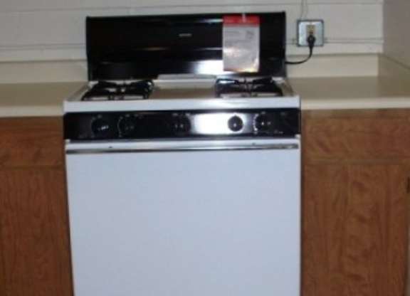 A white oven with a black stove top sits on a kitchen counter.