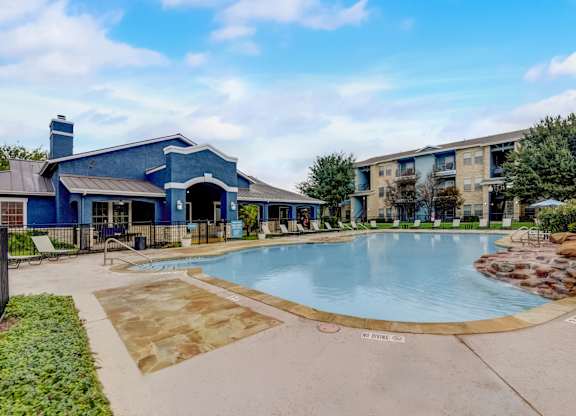 A blue building with a pool in front.