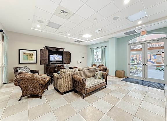 A clubhouse lounge area with a television and couches.