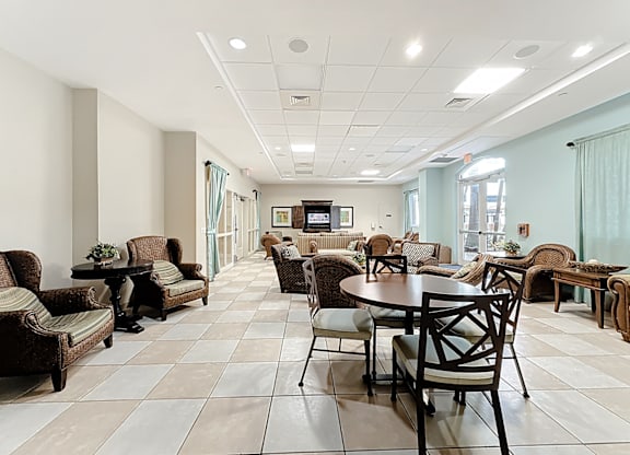 A spacious clubhouse lounge area with a variety of furniture including chairs, couches, and tables.