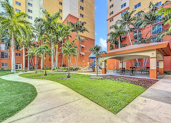 A courtyard with a grassy area and a concrete walkway.