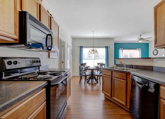 A kitchen with wooden cabinets and a black stove top oven at Ethan Pointe Apartments, Greensboro, NC, 27215