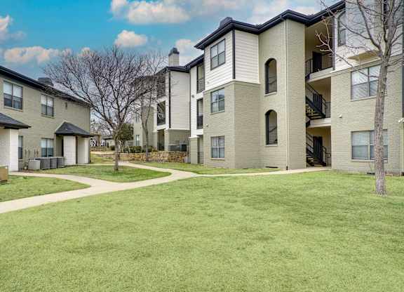 Apartment complex with a green lawn in front.