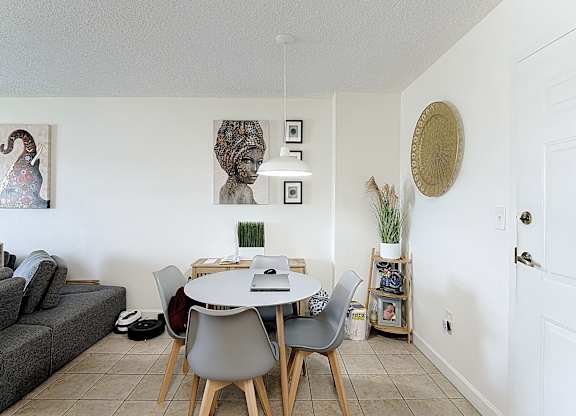 A dining room with a grey table and chairs.