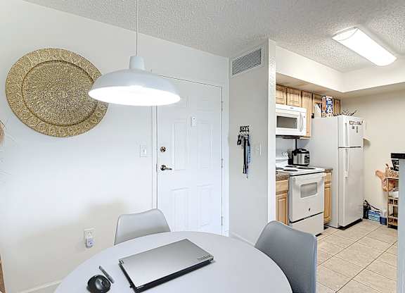 A white kitchen with a table and chairs.