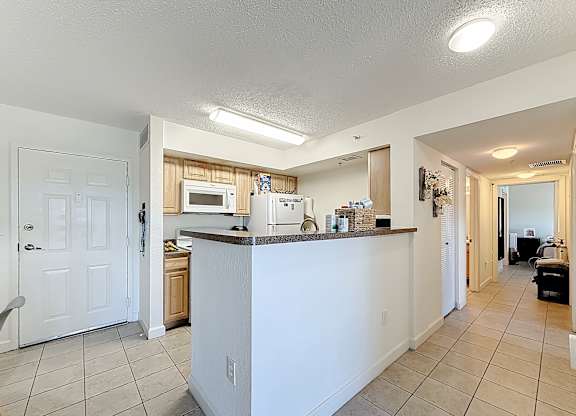 A kitchen with white cabinets and a white door.