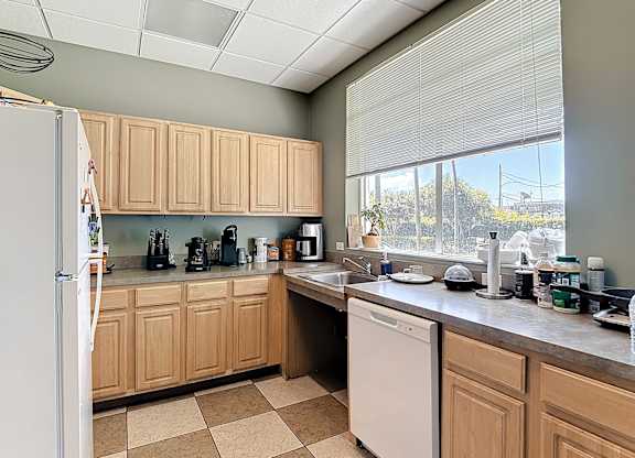 A kitchen with wooden cabinets and a white dishwasher.