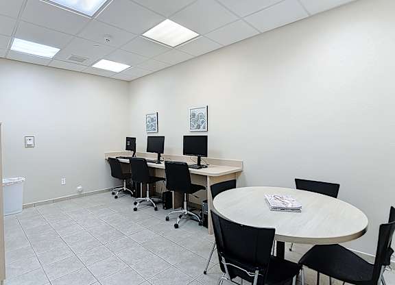 A conference room with a round table and chairs.