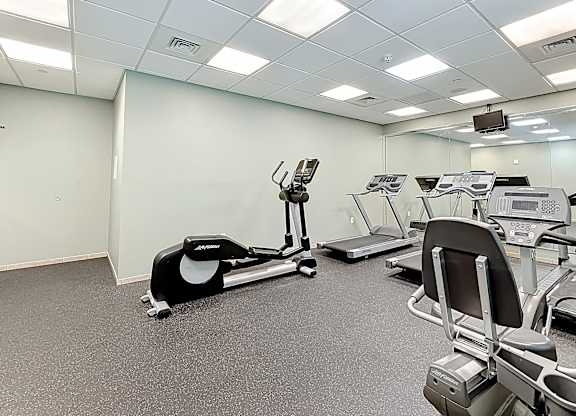 A gym with treadmills, elliptical machines, and other exercise equipment.