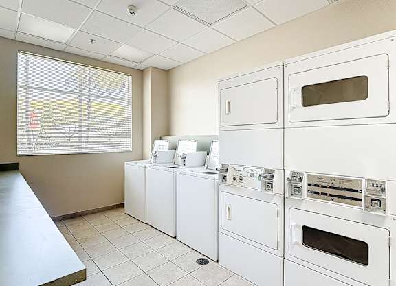 A row of white ovens are lined up in a room.