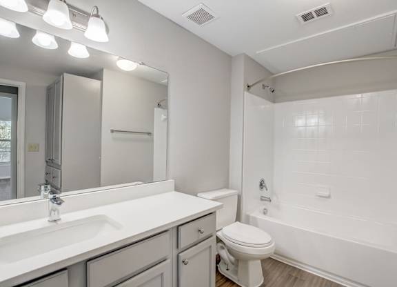 A white bathroom with a toilet, sink, and bathtub.