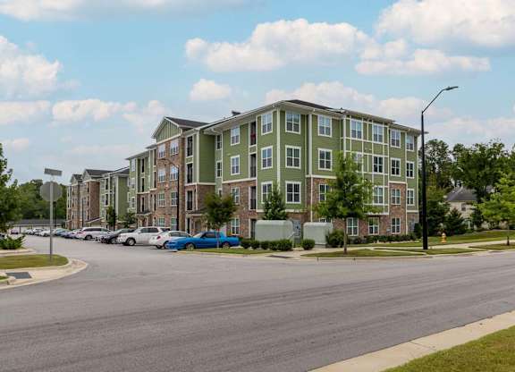 A street view of a residential area with apartment buildings and parked cars at Foxwood Apartments, Raleigh-Durham, NC