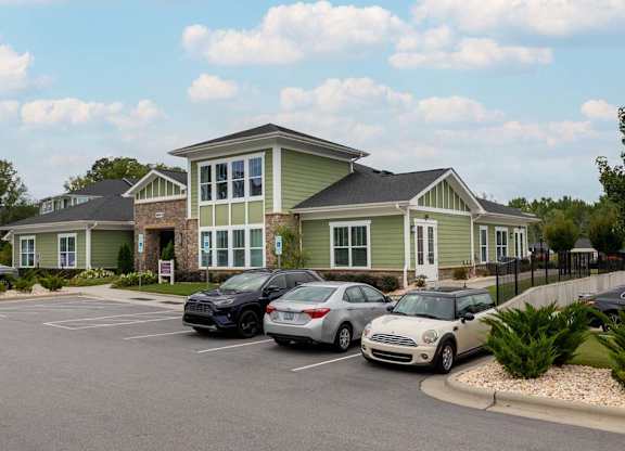 A parking lot with cars and a building in the background at Foxwood Apartments, North Carolina
