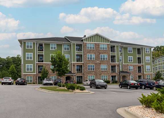 A large apartment complex with a parking lot in front at Foxwood Apartments, Raleigh-Durham, NC, 27616