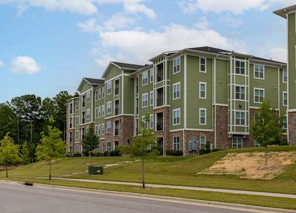 Apartment building with green and grey exterior on a sunny day at Foxwood Apartments, Raleigh-Durham, North Carolina