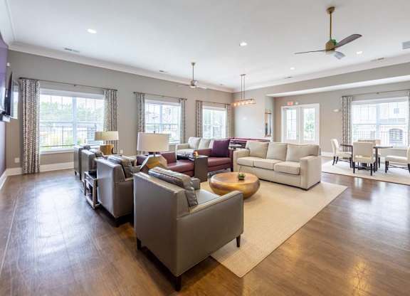 A spacious living room with a variety of seating options and a large rug at Foxwood Apartments, Raleigh-Durham, NC