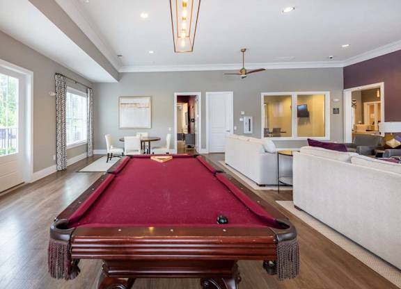 A pool table is in the middle of a room with a ceiling fan at Foxwood Apartments, Raleigh-Durham, NC, 27616