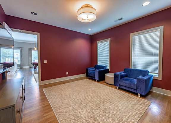 A living room with a red wall and a beige rug at Foxwood Apartments, Raleigh-Durham, NC, 27616