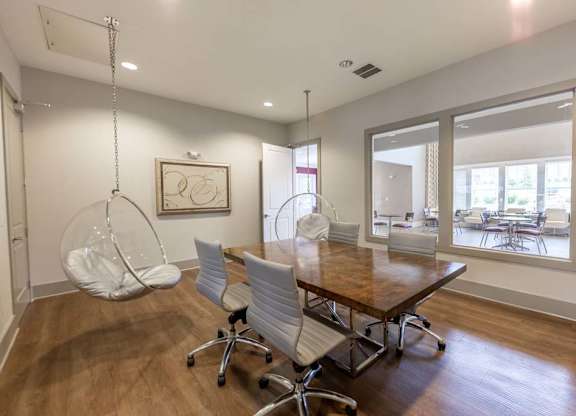 A room with a wooden table and white chairs at Foxwood Apartments, Raleigh-Durham, North Carolina