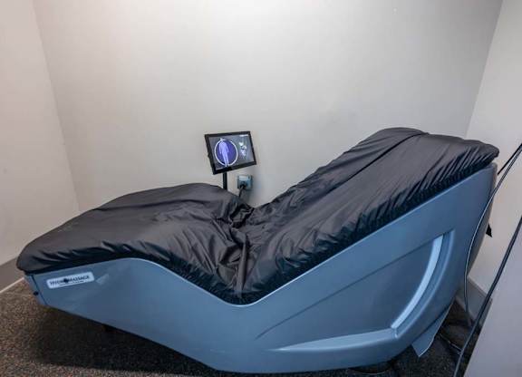 A massage bed with a black cover and a small monitor on top at Foxwood Apartments, Raleigh-Durham, NC