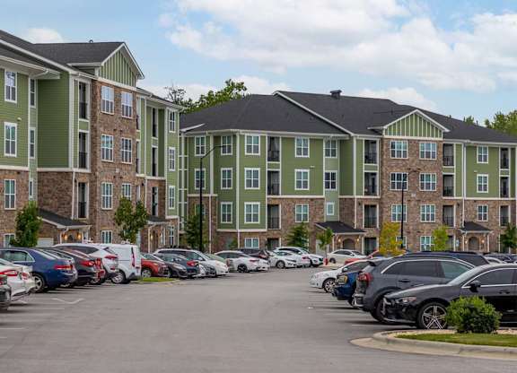 A parking lot with cars and apartment buildings in the background at Foxwood Apartments, Raleigh-Durham, 27616