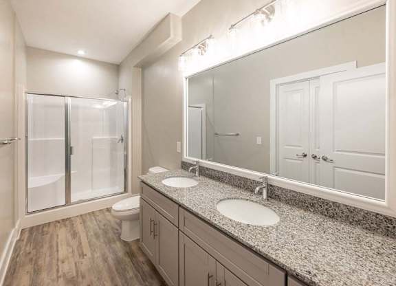 A bathroom with a toilet, sink, and mirror at Foxwood Apartments, Raleigh-Durham, 27616