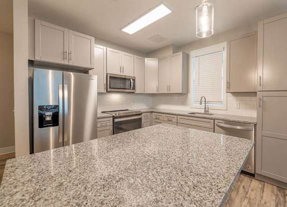 A kitchen with a granite countertop and stainless steel appliances at Foxwood Apartments, North Carolina