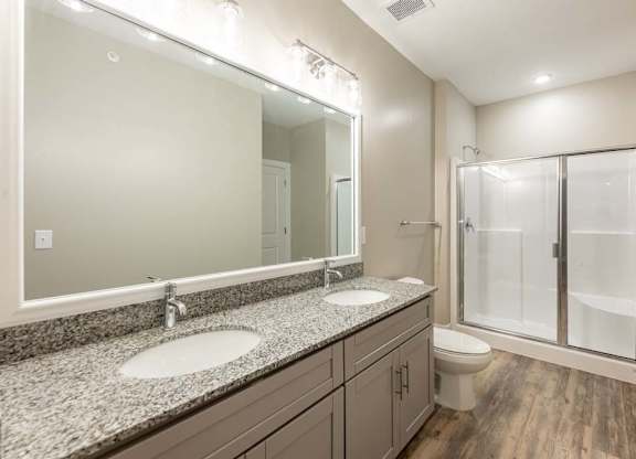 A bathroom with a granite countertop and a walk-in shower at Foxwood Apartments, Raleigh-Durham
