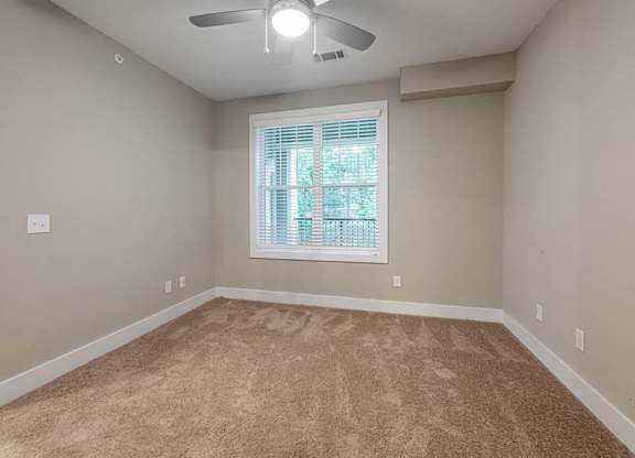 A room with a carpeted floor and a ceiling fan at Foxwood Apartments, Raleigh-Durham, NC, 27616