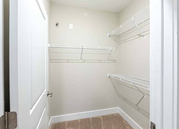 A white closet with a brown rug on the floor at Foxwood Apartments, North Carolina, 27616