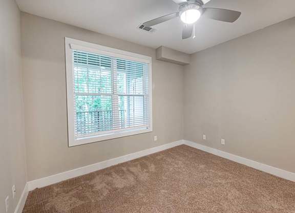 A room with a ceiling fan and a window with blinds at Foxwood Apartments, Raleigh-Durham, North Carolina