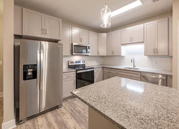 A kitchen with a granite countertop and stainless steel appliances at Foxwood Apartments, North Carolina