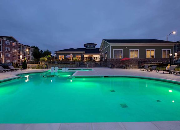 A swimming pool lit up with green lights at dusk at Foxwood Apartments, Raleigh-Durham
