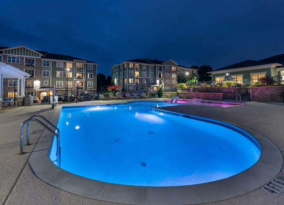 A round swimming pool in a residential area at night. at Foxwood Apartments, Raleigh-Durham, 27616