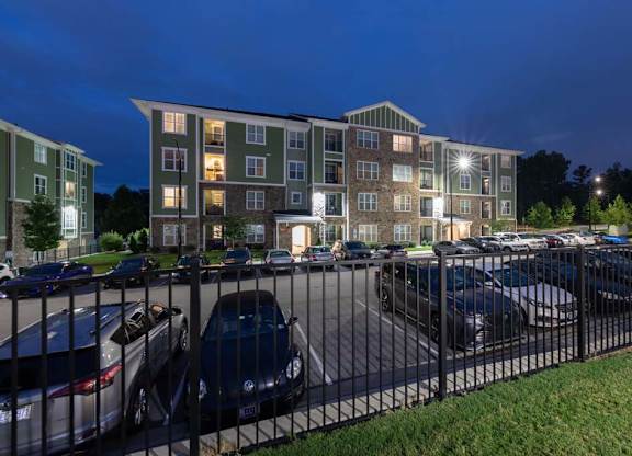 A parking lot with cars and a building in the background at Foxwood Apartments, Raleigh-Durham, NC, 27616
