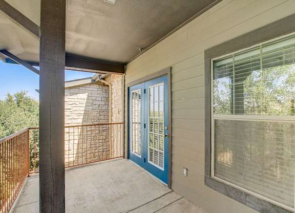 A balcony with a blue door and a window.