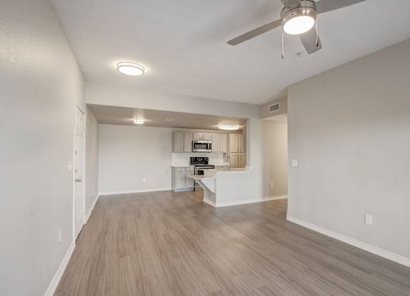 A spacious room with a ceiling fan and light fixture.
