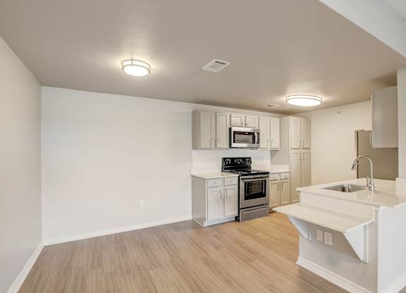 A kitchen with a white counter and stainless steel appliances.