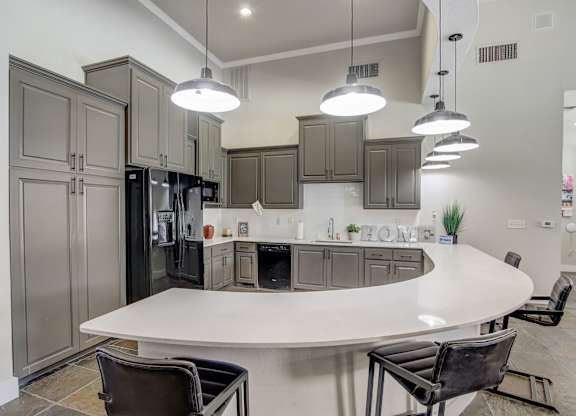 A modern kitchen with a large island and a refrigerator.