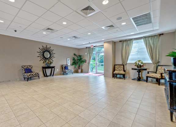 A spacious room with a tiled floor and a large mirror on the wall.